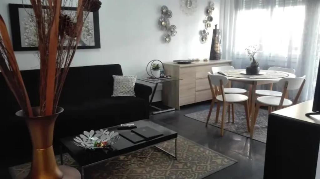 sala de estar con sofá negro y mesa en City Center Comfortable Studio Apartment, en Kavala