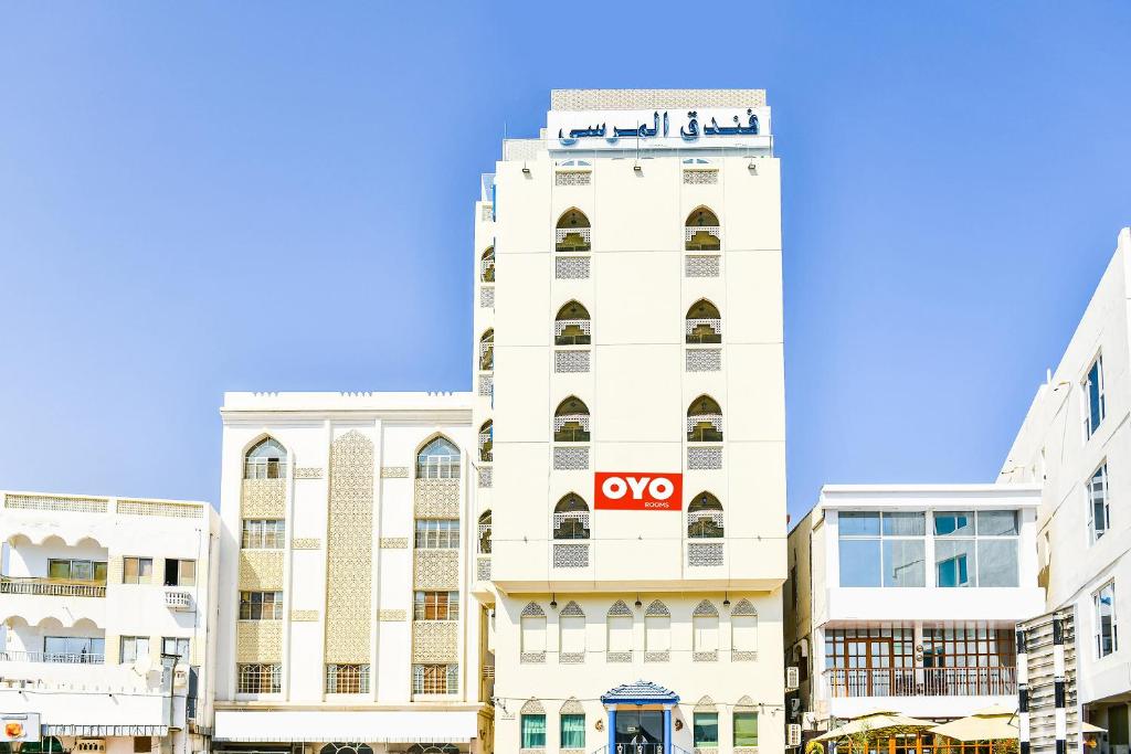 OYO 137 Marina Hotel في مسقط: مبنى أبيض عليه علامة أوميغا