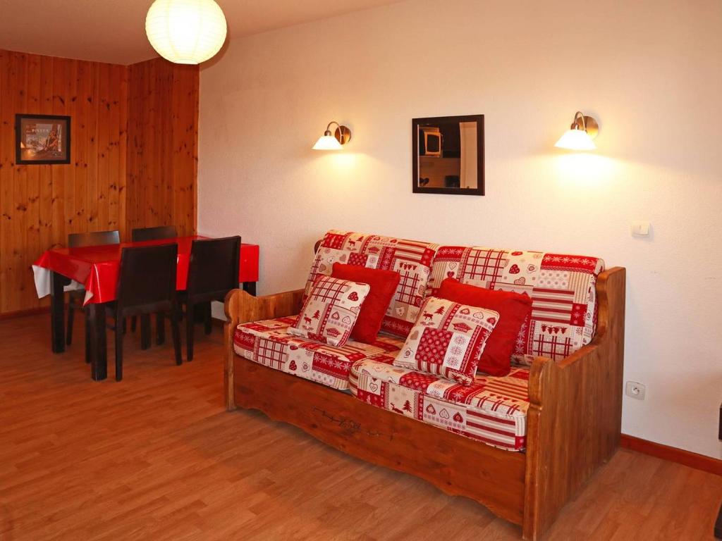 ein Wohnzimmer mit einem Sofa mit Kissen und einem Tisch in der Unterkunft Appartement Les Orres, 2 pièces, 4 personnes - FR-1-322-130 in Les Orres