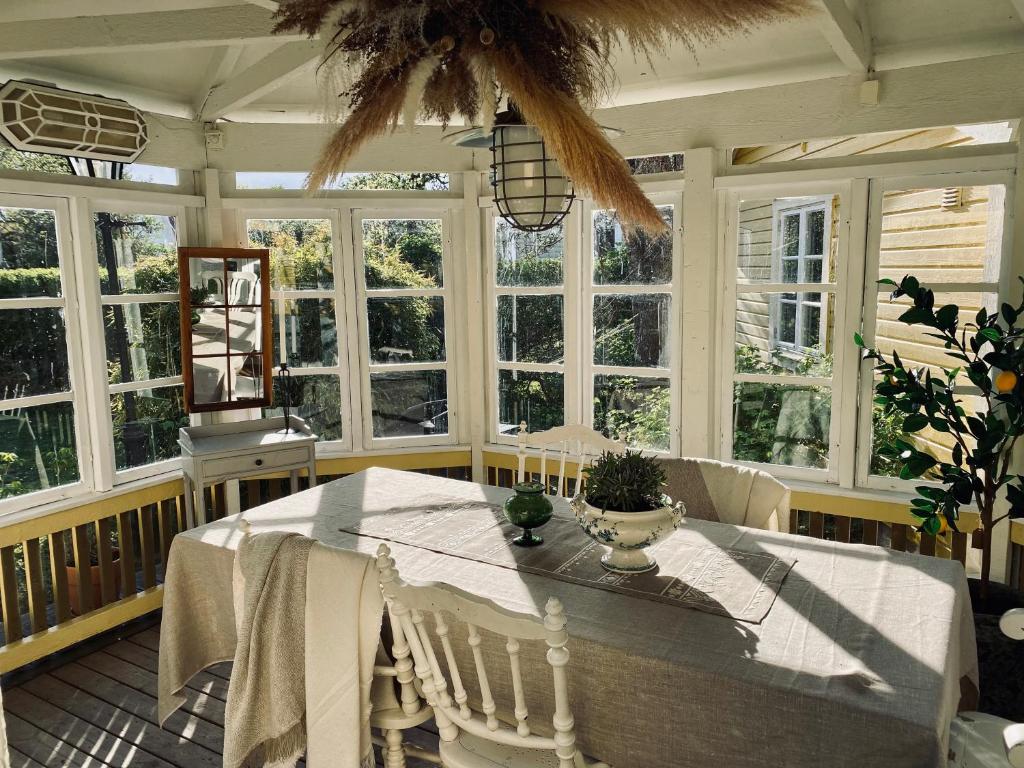 a dining room with a white table and windows at Villa Sol Bed & Breakfast in Borgholm