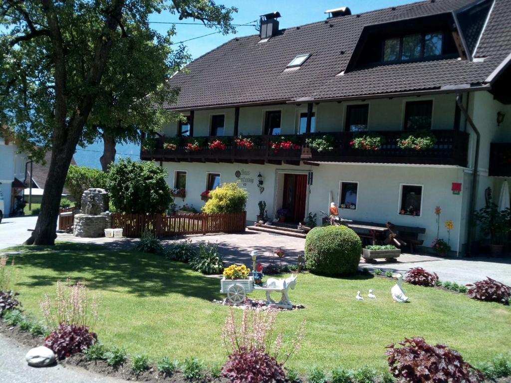 a house with a yard with birds in front of it at Ferienwohnung Haus Gatternig in Seeboden