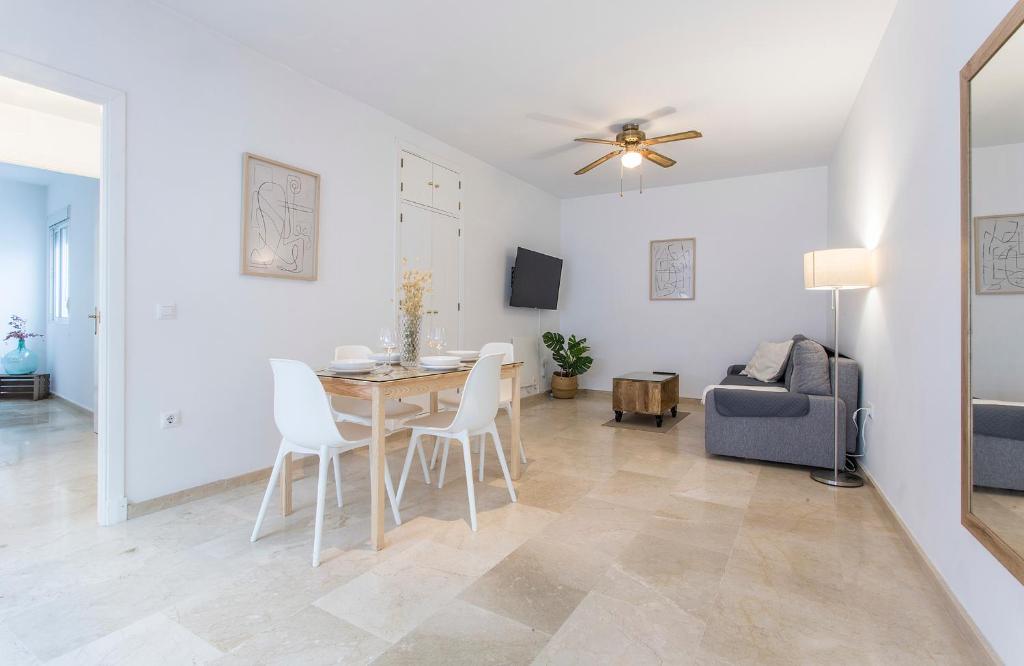 a dining room and living room with a table and chairs at Azvalia - Larga 112 in El Puerto de Santa María