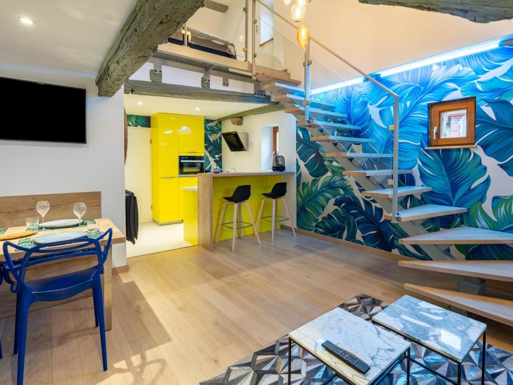 een woonkamer met een trap en een muurschildering bij Le Pinot Gris in Riquewihr