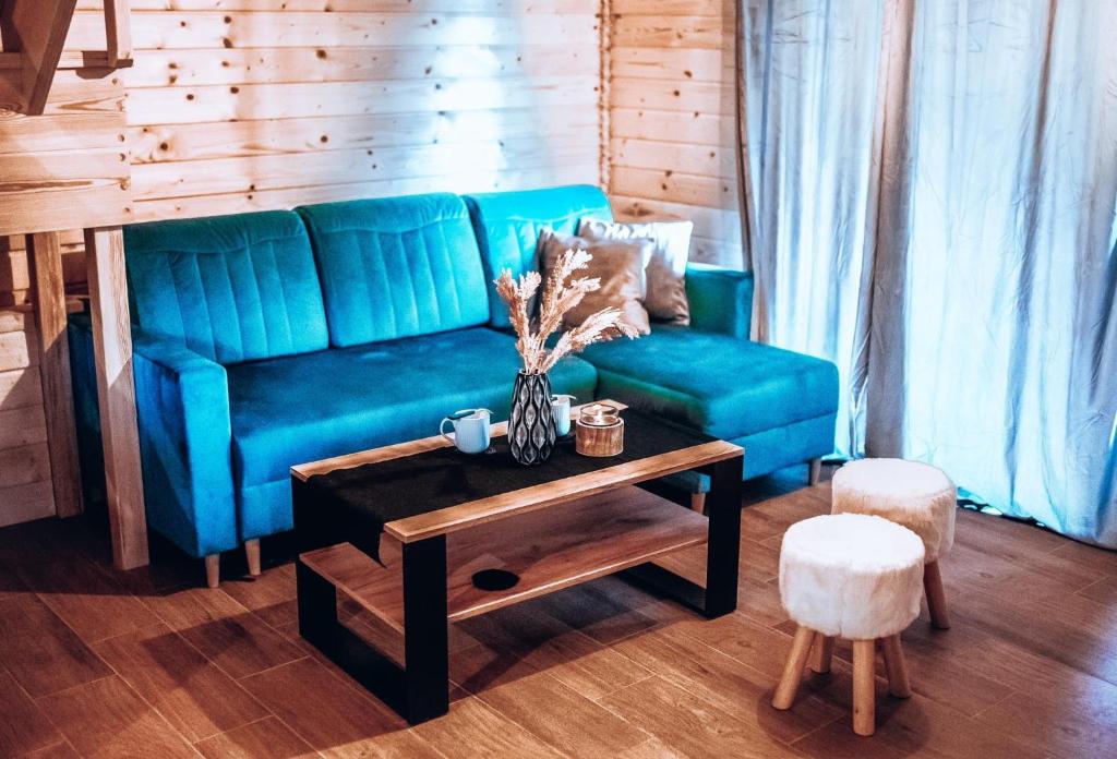 a blue couch in a living room with a table at Dychnij Se in Szczyrk