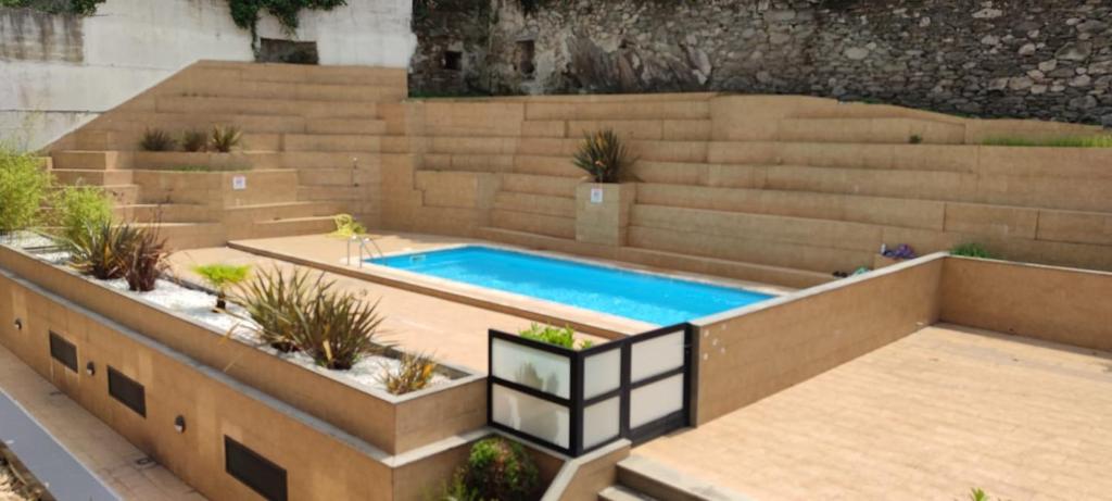una piscina en un patio trasero con una pared de retención en Apartamento Piscina 1G by Urraca Suites Viveiro, en Viveiro