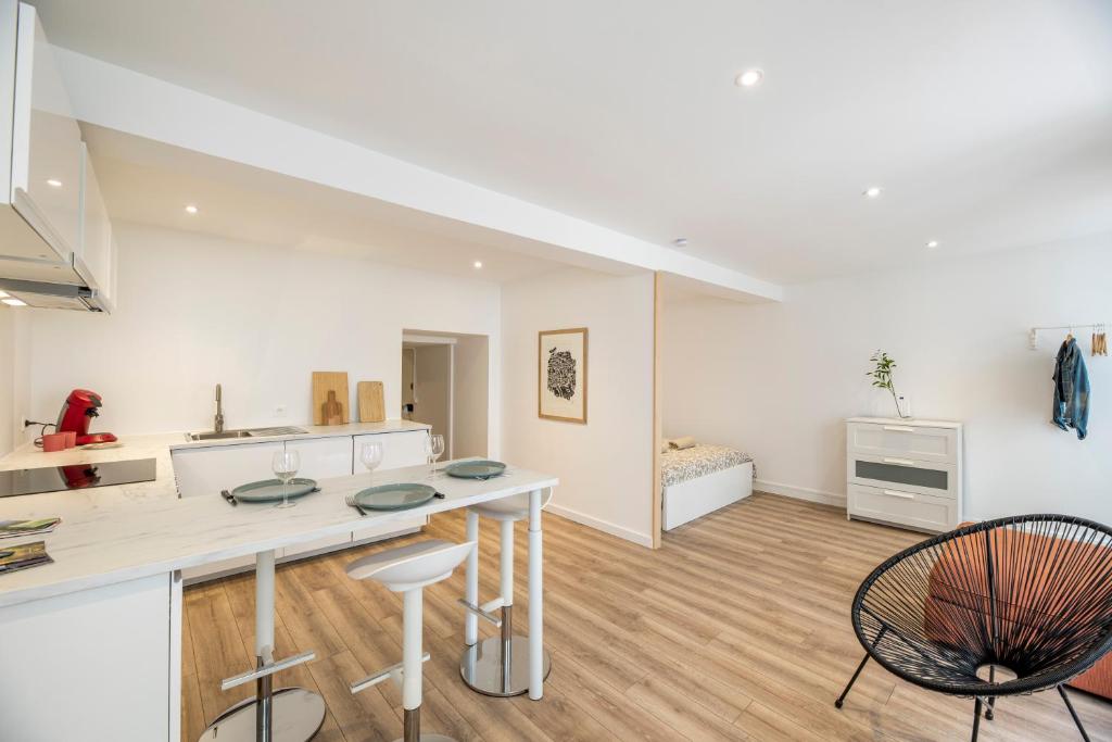 cocina y sala de estar con mesa y sillas en Quartier du château, superbe appartement avec parking, en Pau