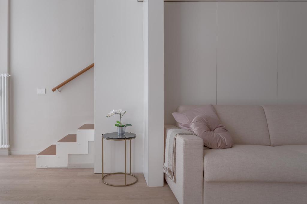 a living room with a couch and a staircase at Touch&Go - via Gaetano Previati 38, Milano in Milan