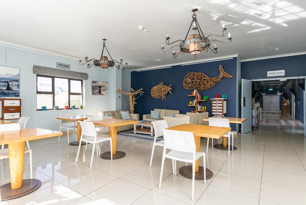 a dining room with wooden tables and chairs at Zzzone Boutique Hostel in Hermanus