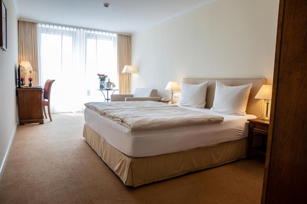 um quarto de hotel com uma cama grande e uma janela em Altstadthotel Messerschmitt em Bamberg