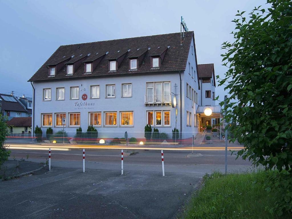 a large white building on the side of a street at Hotel Neckartal in Köngen