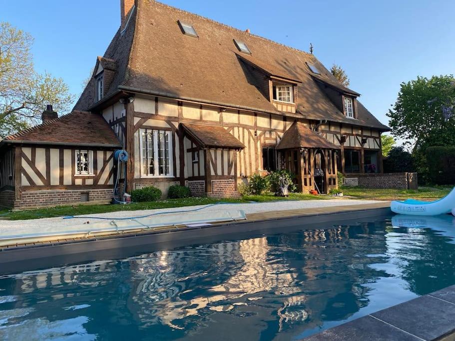 une maison avec une piscine devant dans l'établissement Belle demeure Normande dans son écrin de verdure., à Manneville-sur-Risle