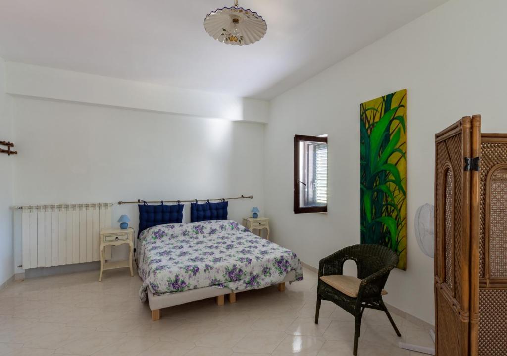 um quarto com uma cama e uma cadeira em B&B Mesa Gaia - Irpinia em Teora