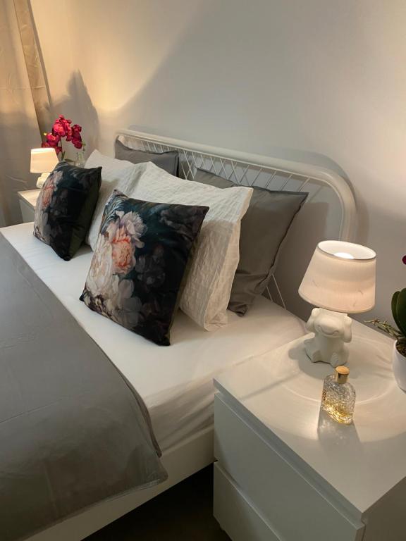 a white bed with two pillows on it with a lamp at Apartments Lily in Ljubljana