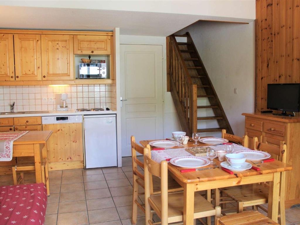 une cuisine avec une table en bois, des chaises et un escalier dans l'établissement Duplex 3 Pièces 6 couchages à 100m des pistes, Vars Les Claux - FR-1-330B-37, à Vars