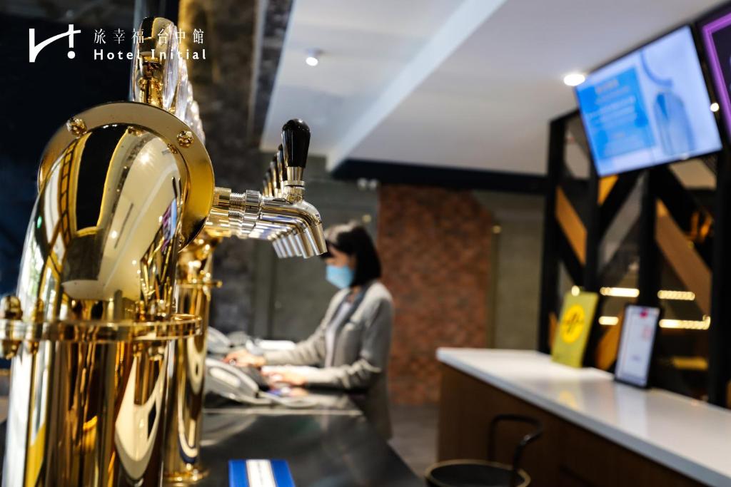 a woman wearing a mask in a store with a gold instrument at Hotel Initial-Taichung in Taichung