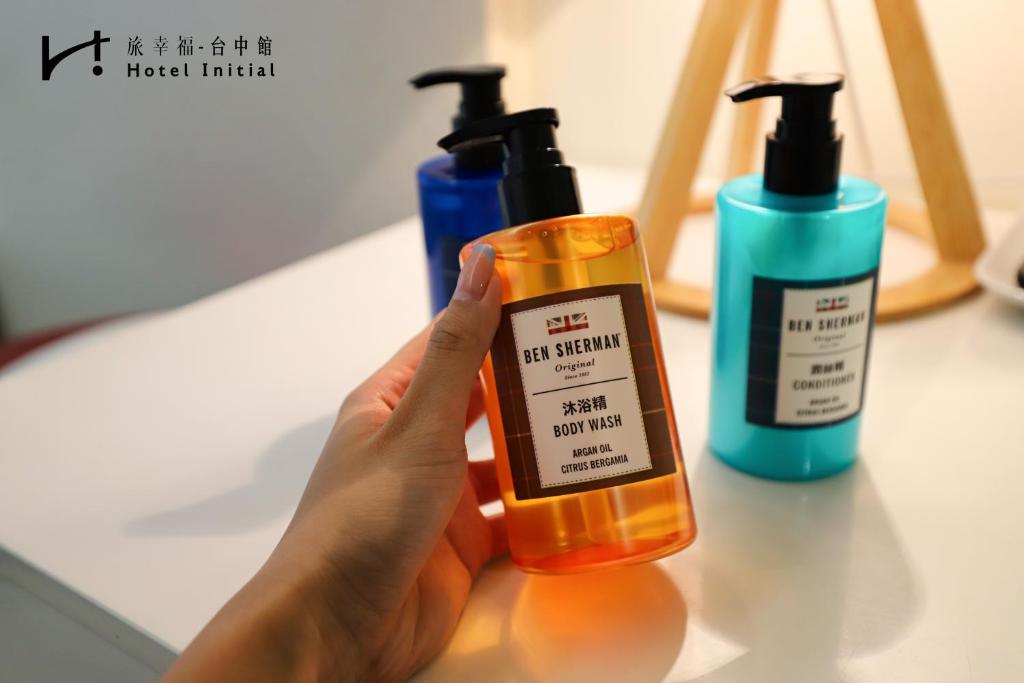 a person holding a bottle of moisturizers on a counter at Hotel Initial-Taichung in Taichung