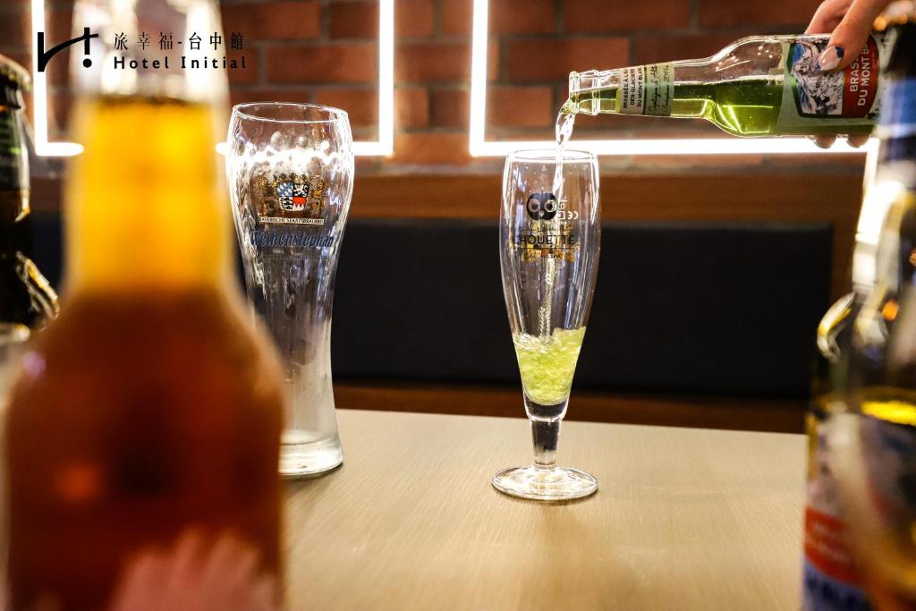 a bottle of champagne is being poured into two glasses at Hotel Initial-Taichung in Taichung