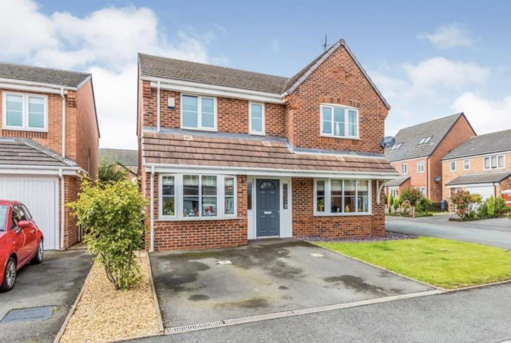 a brick house with a car parked in a driveway at SPACIOUS DETACHED 5 Bedroom4 Bathroom WIFI Parking in Newcastle under Lyme