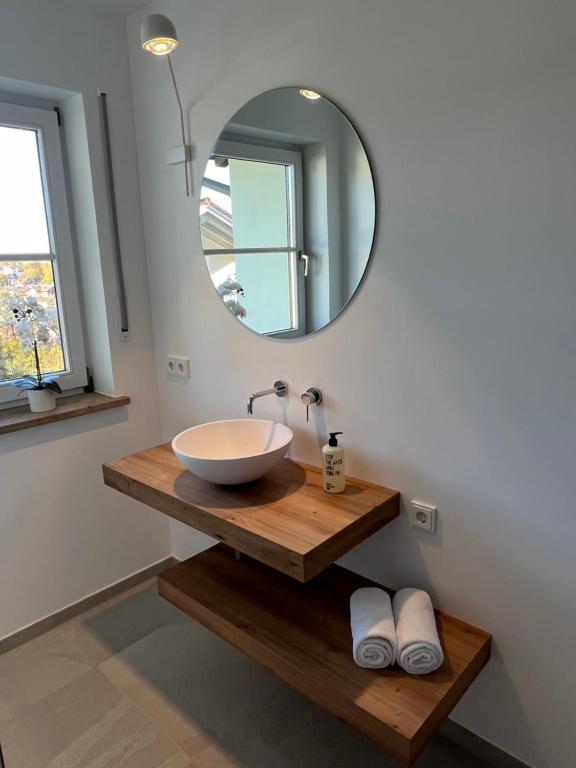 a bathroom with a bowl sink and a mirror at Wanderlust Chiemgau in Bad Endorf