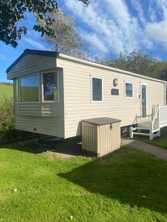 a white trailer with a bench in a yard at Newquay Caravan, Newquay Bay Resort Jetts View 104 in Newquay