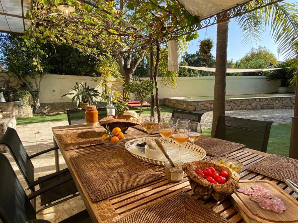 a wooden table with food and drinks on a patio at Villa Elva in Le Plan-de-la-Tour