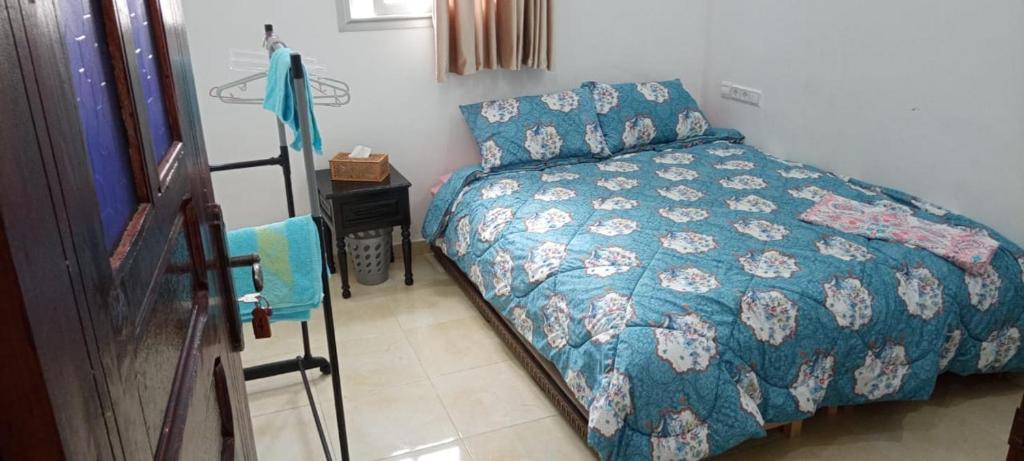 a bedroom with a bed with a blue comforter at Dar Ba Brahim in Rabat