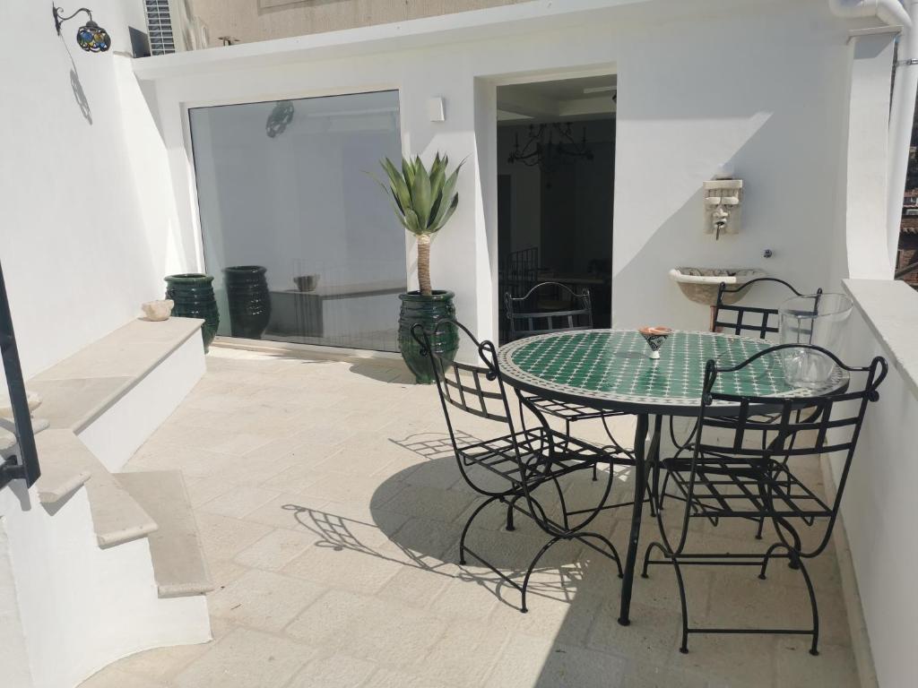uma mesa de vidro e cadeiras num pátio em A Barunedda - charming house with terrace em Taormina