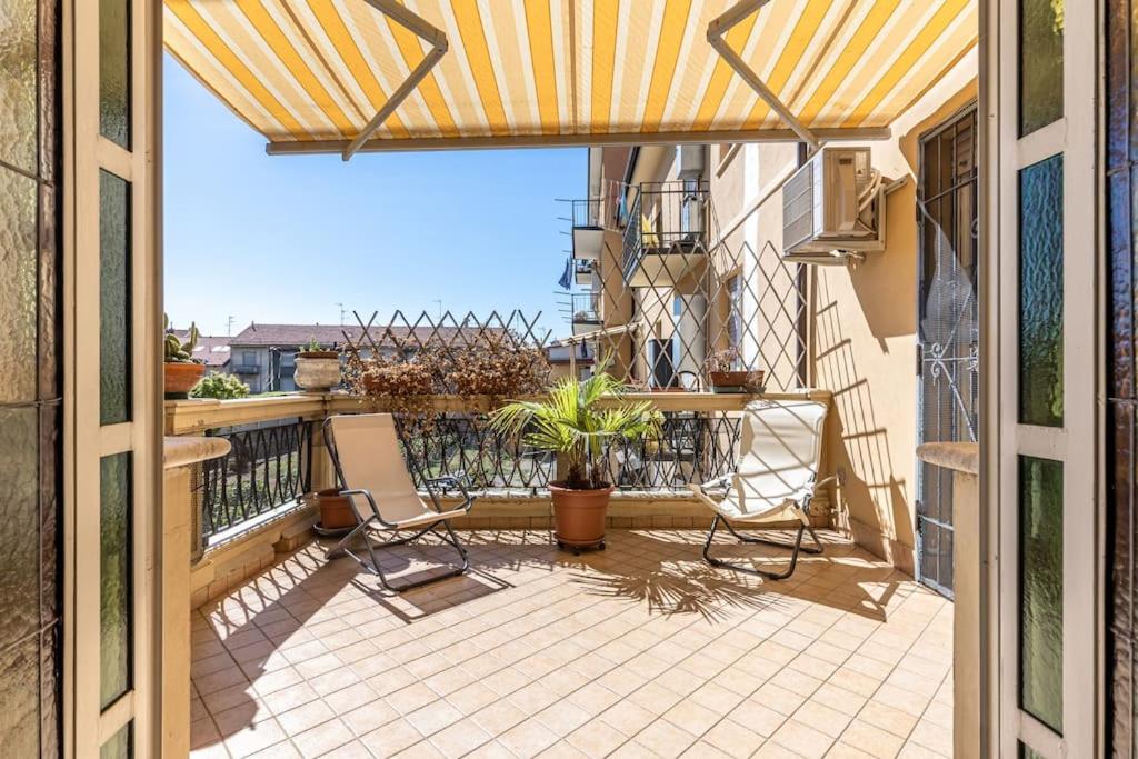 uma varanda com um pátio com uma mesa e cadeiras em Appartamento con Ampia Terrazza - 10 minuti da Torino em Moncalieri