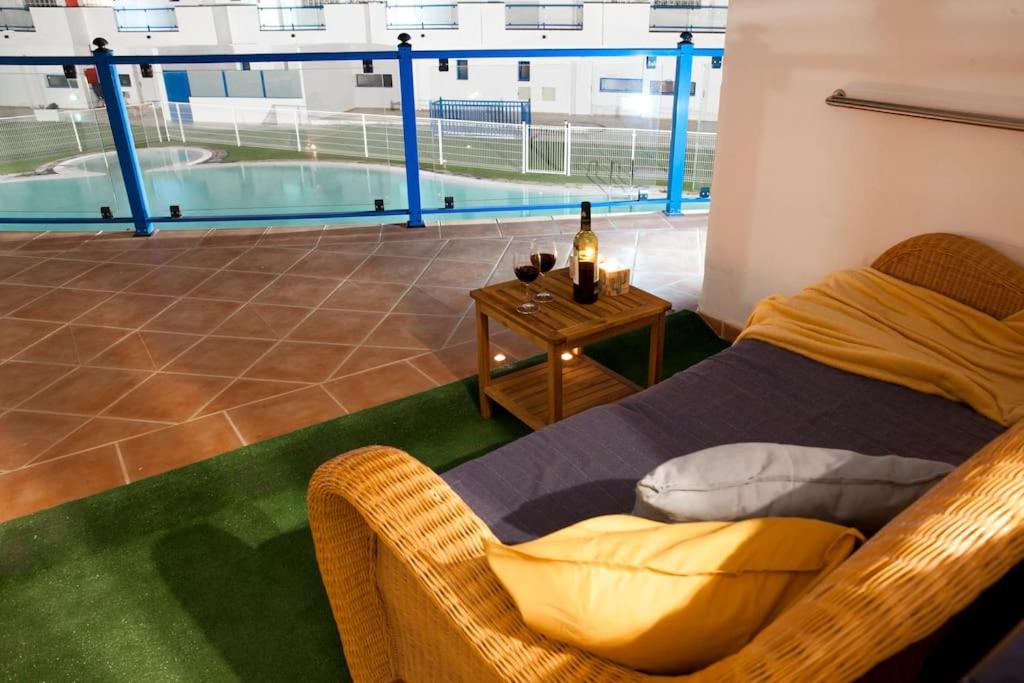 ein Schlafzimmer mit einem Bett mit einem Tisch und einem Pool in der Unterkunft Widok na basen, Home-Office, Wi-Fi Gratis in Costa Calma