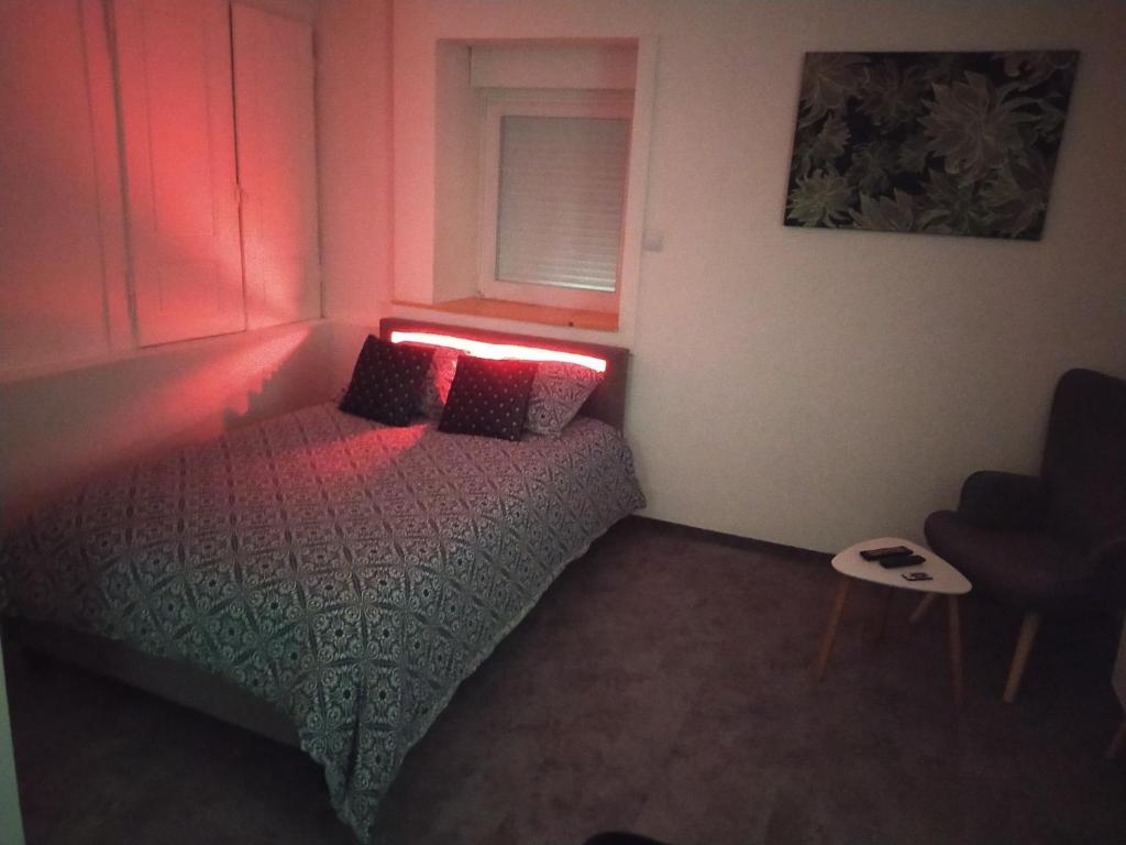 Schlafzimmer mit einem Bett mit roter Lampe in der Unterkunft *** STUDIO 39 *** in Morbier