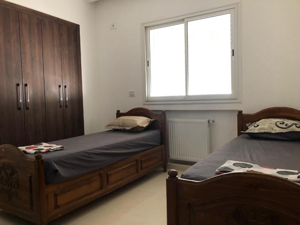 - une chambre avec 2 lits et une fenêtre dans l'établissement Maison Karam, à Rabat
