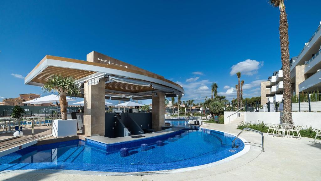 een zwembad in een resort met een prieel bij Luxury apartment in Flamenca Village/Orihuela Costa in Orihuela-Costa