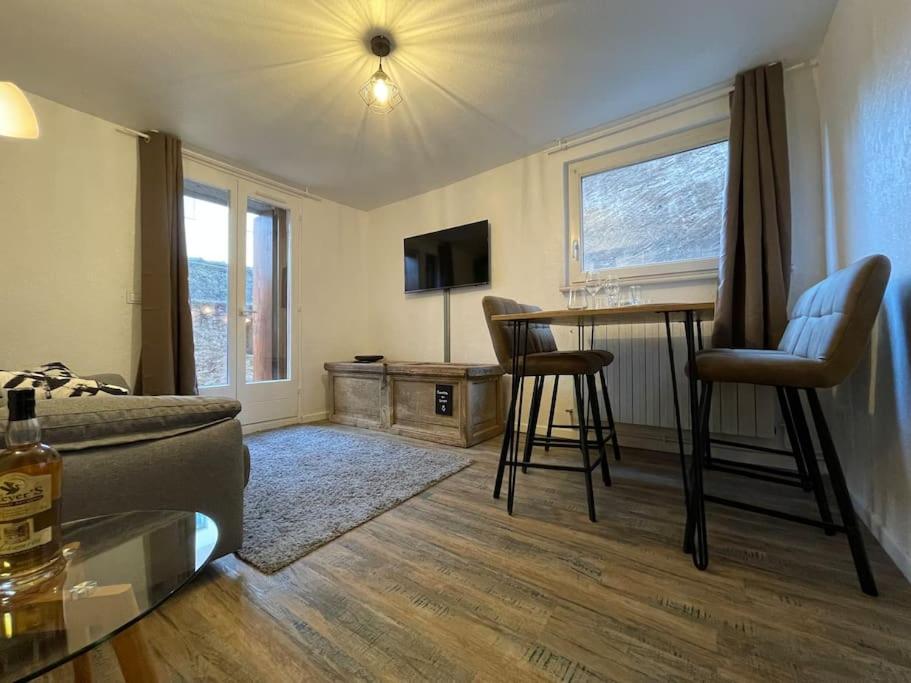 ein Wohnzimmer mit einem Bett und einem Tisch und Stühlen in der Unterkunft L'Alsacien - Appartement avec Terrasse - Cuisine équipée - WiFi Gratuit in Sélestat