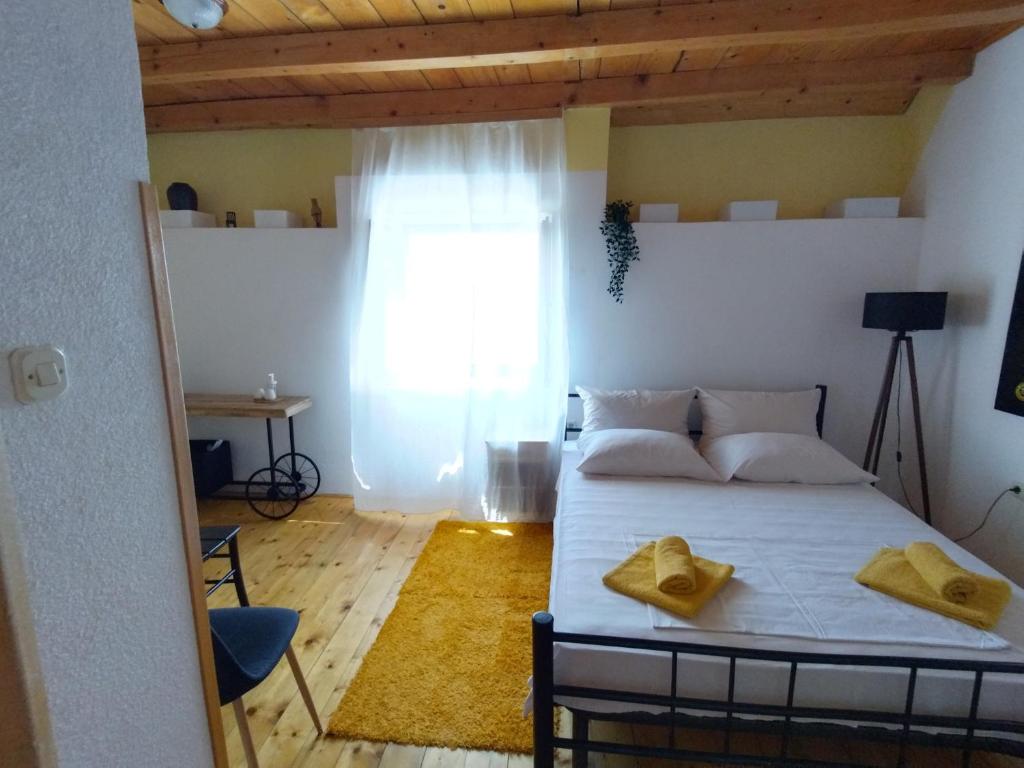 a bedroom with a bed with yellow towels on it at Apartments Elena & Damir in Vis