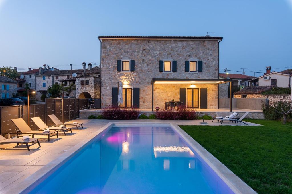 a swimming pool in front of a house at Villa Hizina Veleniki in Poreč