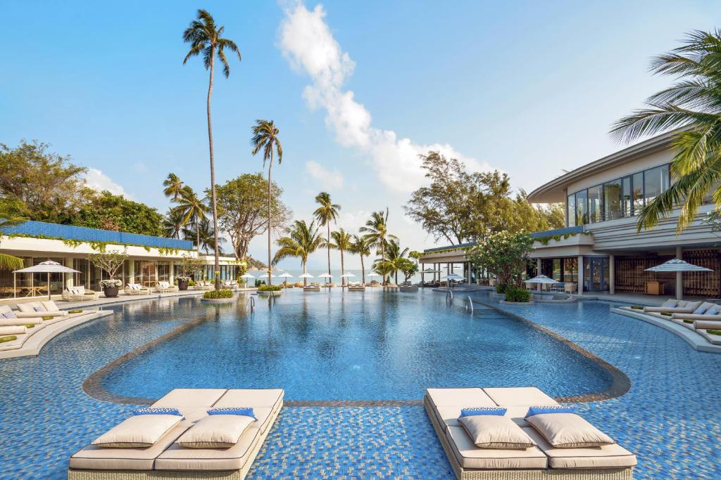 a swimming pool with lounge chairs and a resort at Melia Koh Samui - SHA Extra Plus in Choeng Mon Beach