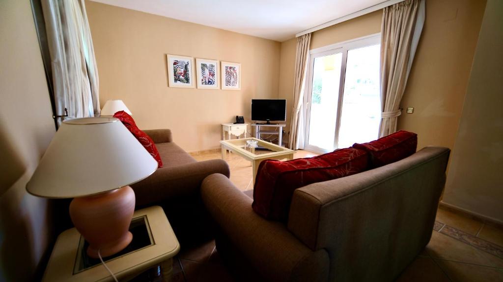 a living room with a couch and a lamp at Marbella Beach Resort at Club Playa Real in Marbella