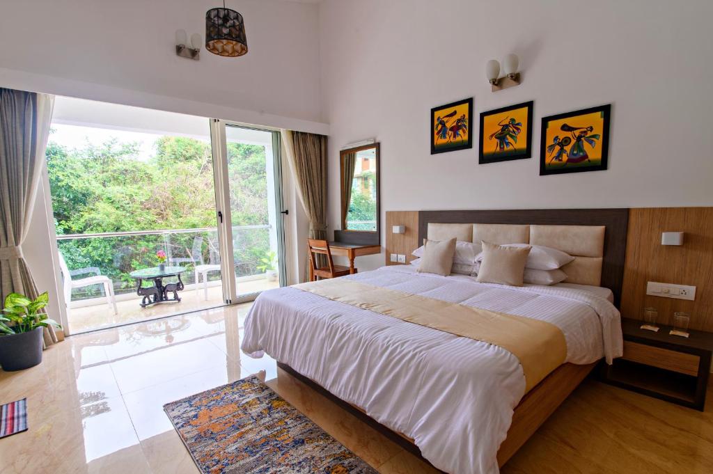 um quarto com uma cama grande e uma janela grande em Lotus & Orchid Villas by Ramnath Homes em Sangolda