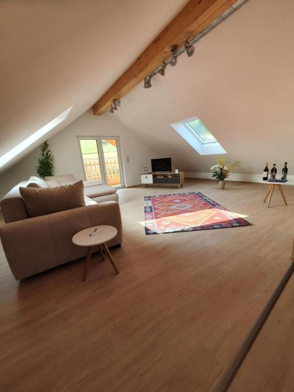 a living room with a couch and a rug at Ferienwohnung 80 qm mit überdachtem Balkon und Terrasse im Neubau in Bad Mergentheim