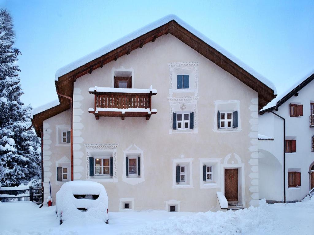 uma casa grande com neve no chão em Chesa Wazzau em Bever