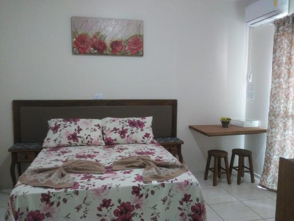 1 dormitorio con 1 cama y 1 mesa con sillas en Pousada Pingo d' Água, en Bombinhas