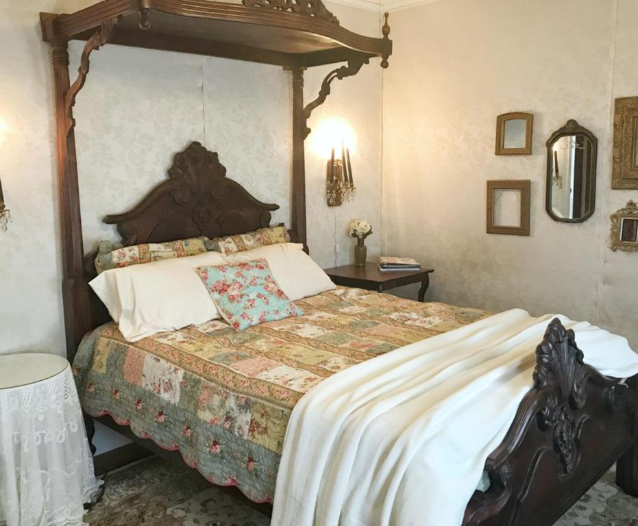 a bedroom with a large bed with a wooden canopy at The Bissing House in Hays