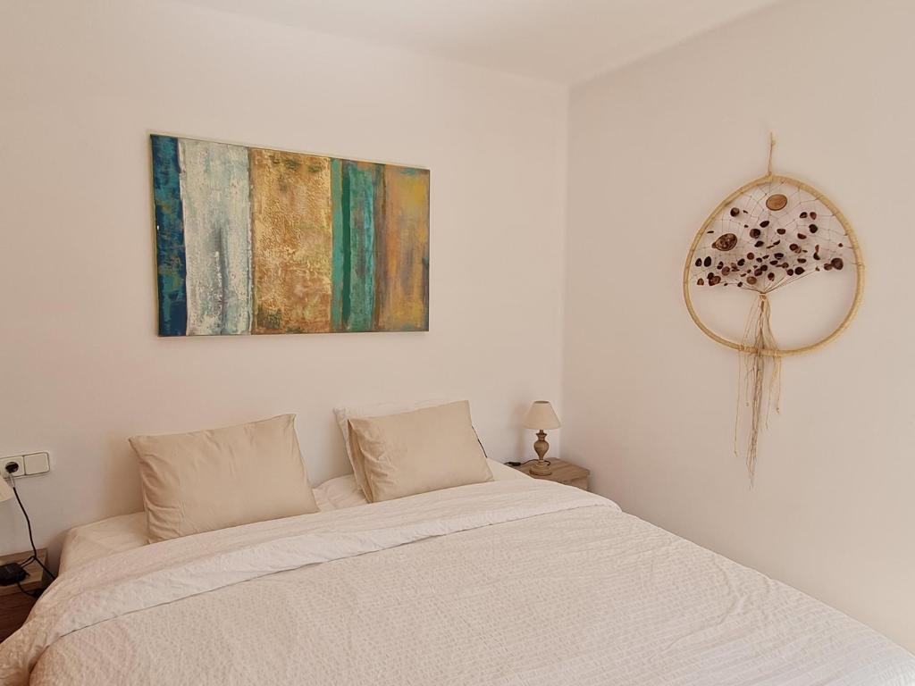 sypialnia z łóżkiem i obrazem na ścianie w obiekcie Cozy Waterman beach house w Costa Teguise