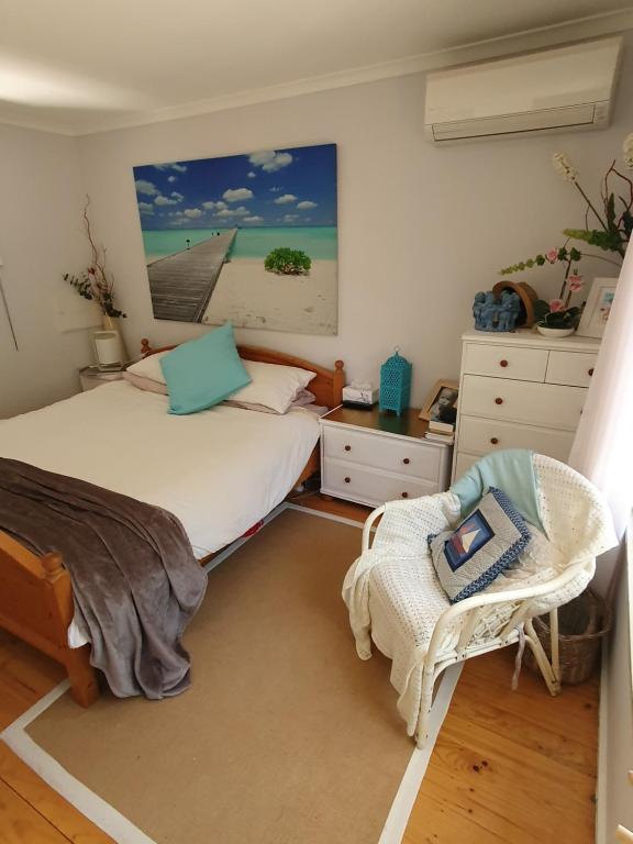 um quarto com duas camas e uma cadeira. em Cozy Beachcomber @Smith's Beach em Smiths Beach