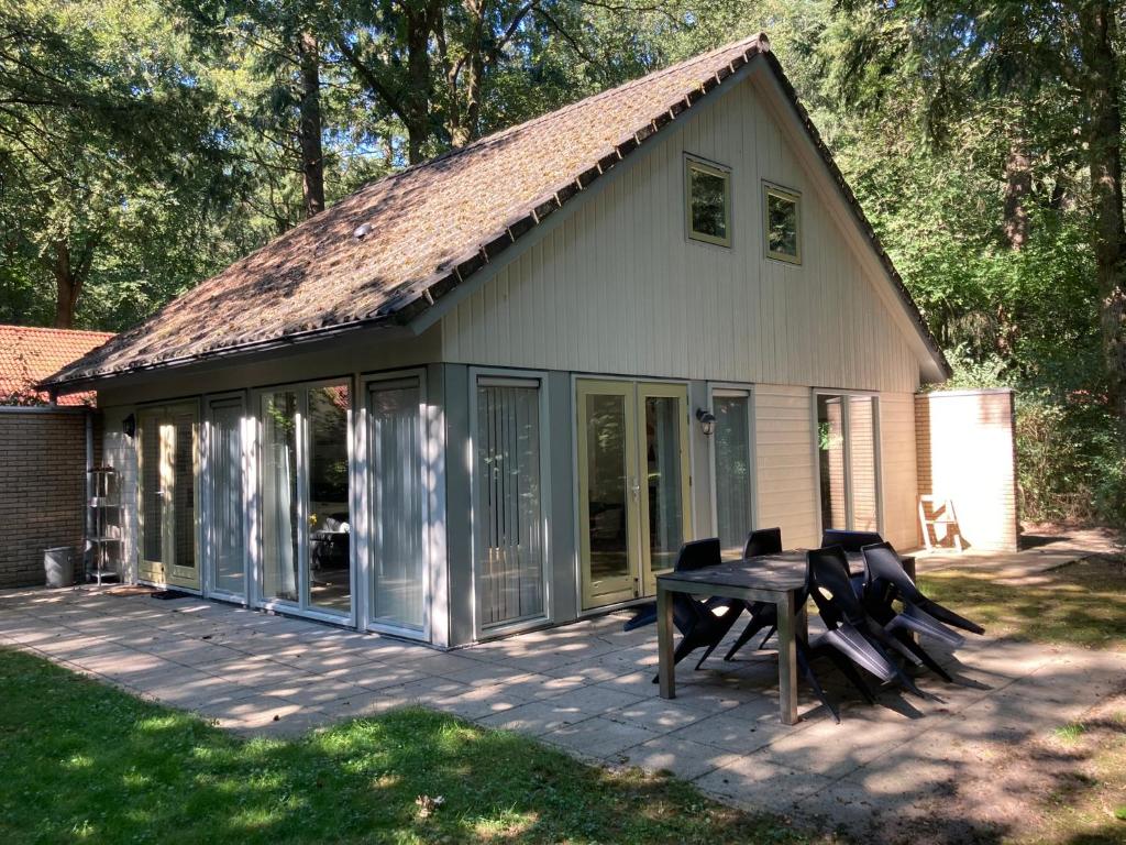 ein Haus mit einem Picknicktisch und Stühlen auf einer Terrasse in der Unterkunft Karekiet 42 in Oudemirdum