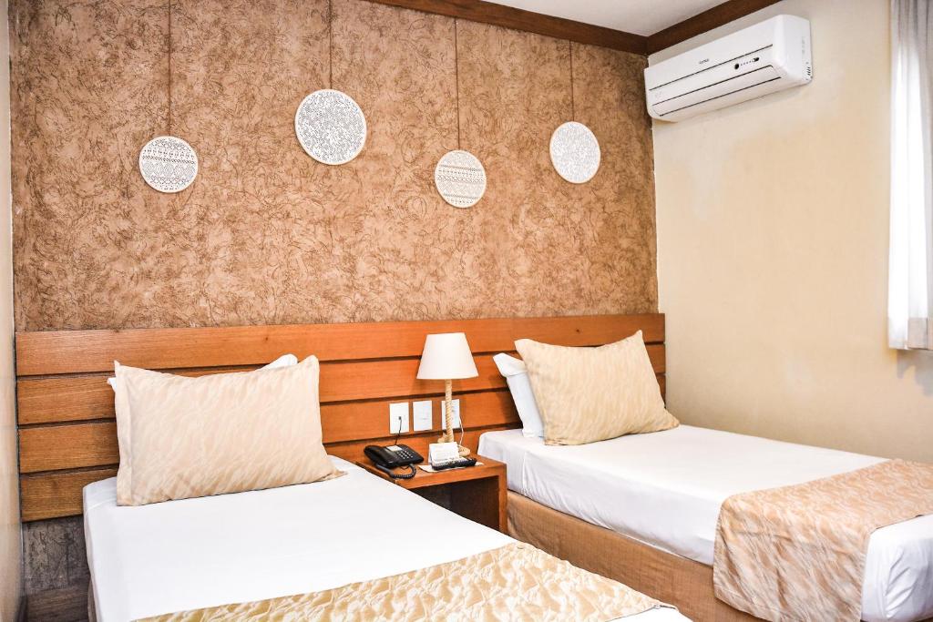 Cette chambre comprend 2 lits et une table. dans l'établissement Carppa Hotel, à Fortaleza