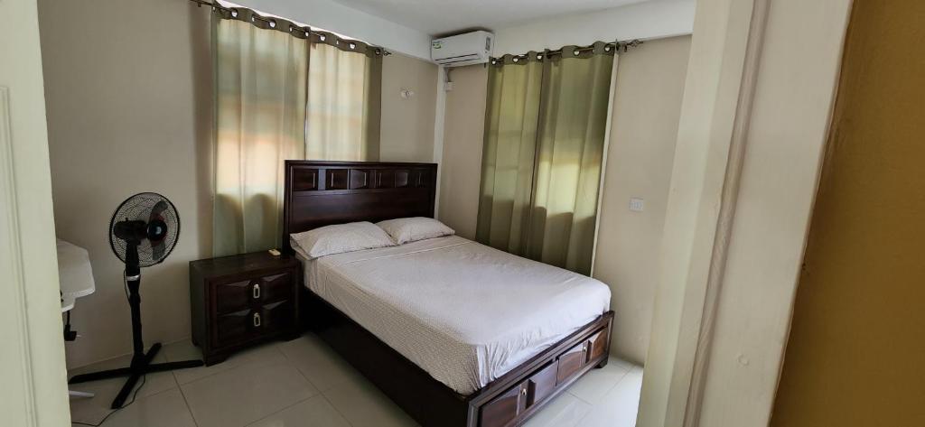 a small bedroom with a bed and a fan at vacation home in Roseau