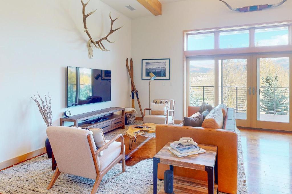 sala de estar con sofá y TV en Modern Mountain Magic en Eagle