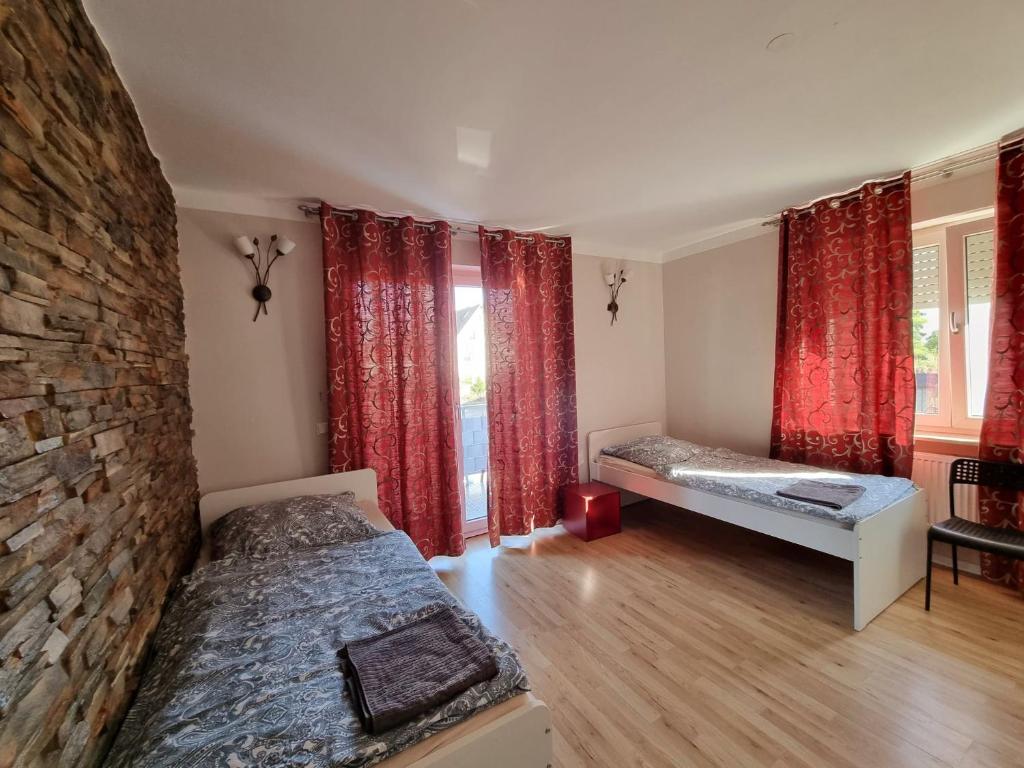a bedroom with two beds and a stone wall at Monteurunterkunft Cadolzburg in Cadolzburg