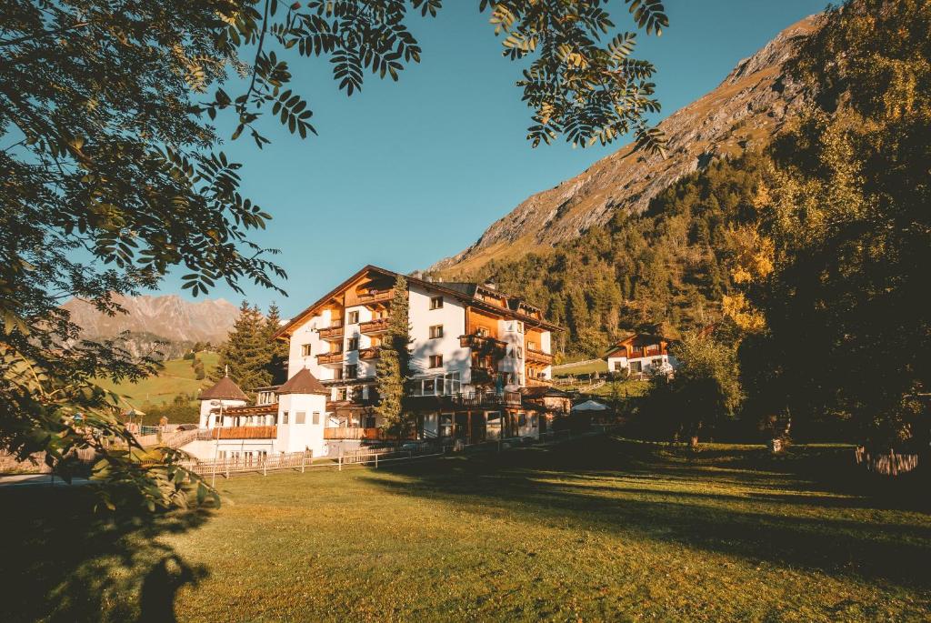 ein großes Gebäude vor einem Berg in der Unterkunft Familienhotel Replerhof mit Kinderbetreuung in Prägraten